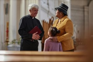 Priest discussing ceremony with people