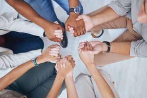 Support, prayer and trust with hands of people praying in spiritual faith and comfort in a meeting